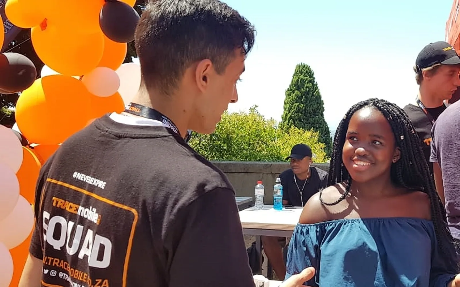 Alter Ego host speaking with a guest at a Trace Mobile activation